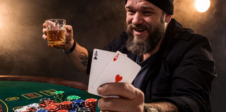 un hombre en una mesa de casino con dos cartas en la mano