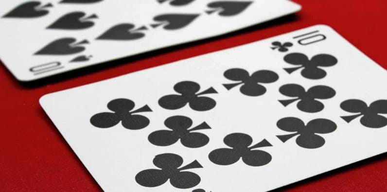 Dos cartas de 10 en una mesa de casino