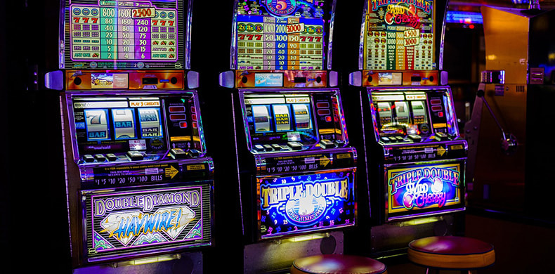 Tres máquinas tragamonedas en un casino 